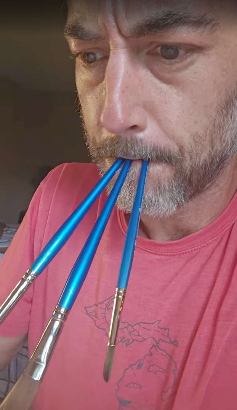 Captain Jezzatron holding three paintbrushes